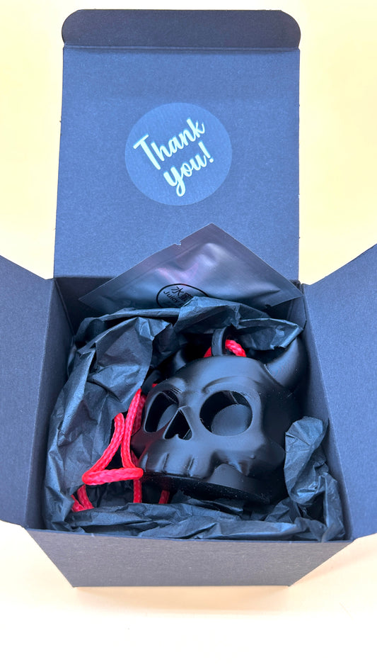 Black skull-shaped object with red accents in a blue box labeled 'Thank You!'.