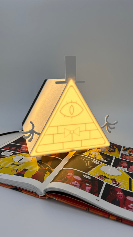 Light-up novelty item shaped like a pyramid with an eye design, placed on an open book.