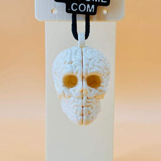 3D printed skull-shaped perfume bottle on a stand with '3D Perfume Com' label.