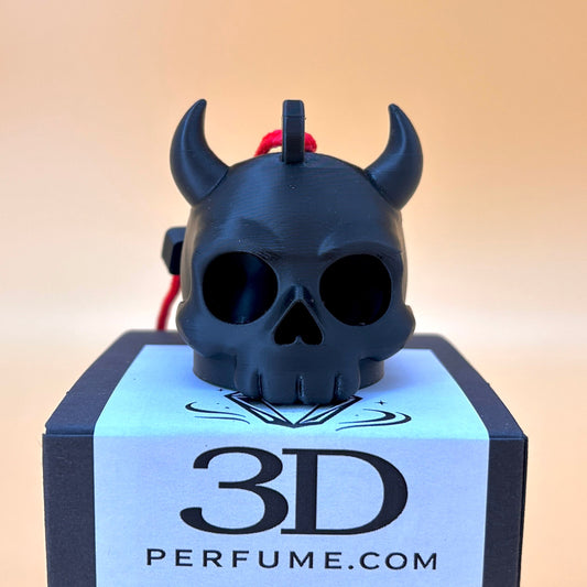 Black skull-shaped perfume bottle with horns on a white box labeled '3D Perfume.com' against a beige background.